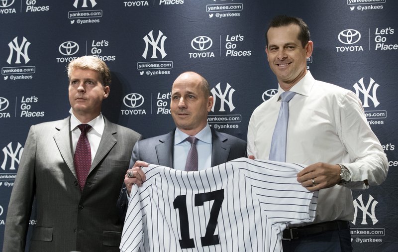 New York Yankees owner Hal Steinbrenner, left, general manager Brian Cashman, center, and Aaron Boone, pose for photographers during a news conference introducing Boone as the baseball team's new manager, Wednesday, Dec. 6, 2017, at Yankee stadium in New York. (AP Photo/Mary Altaffer)