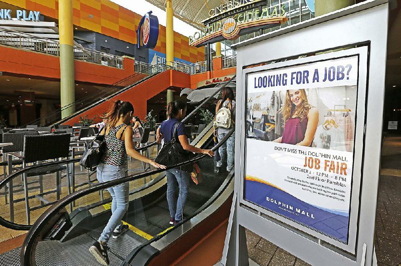 Job-seekers head to a career fair in Sweetwater, Fla., in October. The Labor Department says fewer people filed for unemployment benefits last week.