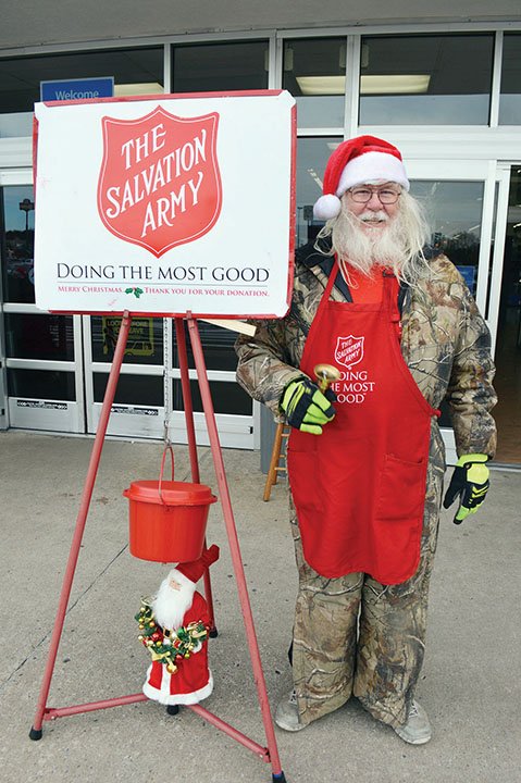 Gerald Finnegan of Conway stands by The Salvation Army Red Kettle at the Walmart Supercenter on Harkrider Street in Conway, where he rings a bell five days a week. Finnegan, 64, said he volunteers to give back because The Salvation Army helped him when he needed it. “I love the kids,” he said. More volunteers are needed to man the kettles, The Salvation Army Conway Corps officers said.