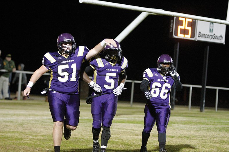 Terrance Armstard/News-Times Junction City's Jack Smith (51) congratulates Hishmma Taylor (5) along with Trey Miner (66) after Taylor's successful run on a two-point conversion during the Dragons' win over Osceola in the 3A semifinals last Friday at David Carpenter Stadium. Tonight, Junction City looks to cap a perfect season by taking on Rivercrest for the 3A state championship. Game time is set for 7 p.m. from War Memorial Stadium in Little Rock.