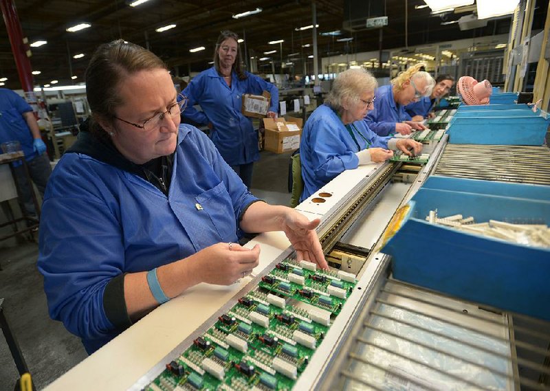 Annagala Jacobs (left), an assembly specialist, adds electrical connectors Tuesday to a circuit board meant for use in an HVAC system  while working at Keytronic EMS in Fayetteville. The company assembles circuit boards for many different applications.