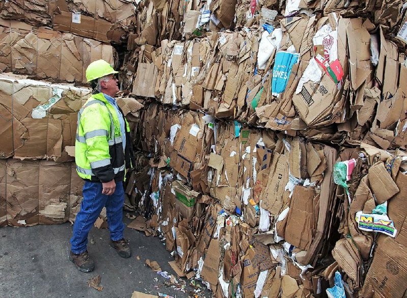 Rusty Miller, plant manager of Waste Management’s Material Recovery Facility in Little Rock, inspects bales of cardboard that will eventually be recycled.