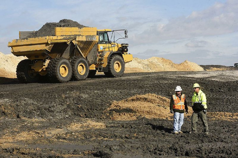 Duke Energy crews remove coal ash from old refuse ponds at a steam plant in Wilmington, N.C., in November. Critics of a proposal to subsidize coal production say such a move could prevent aging plants from closing even if they’re not economical to run.
