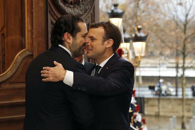 French President Emmanuel Macron (right) greets Lebanese Prime Minister Saad Hariri before a meeting Friday in Paris.
