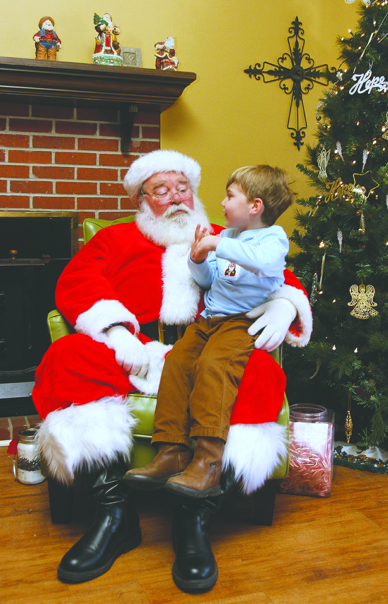 Sitting in Santa's lap: Three-year-old Parker Kuhn takes time to visit with Santa during the Hope Landing Christmas at the Ranch event.