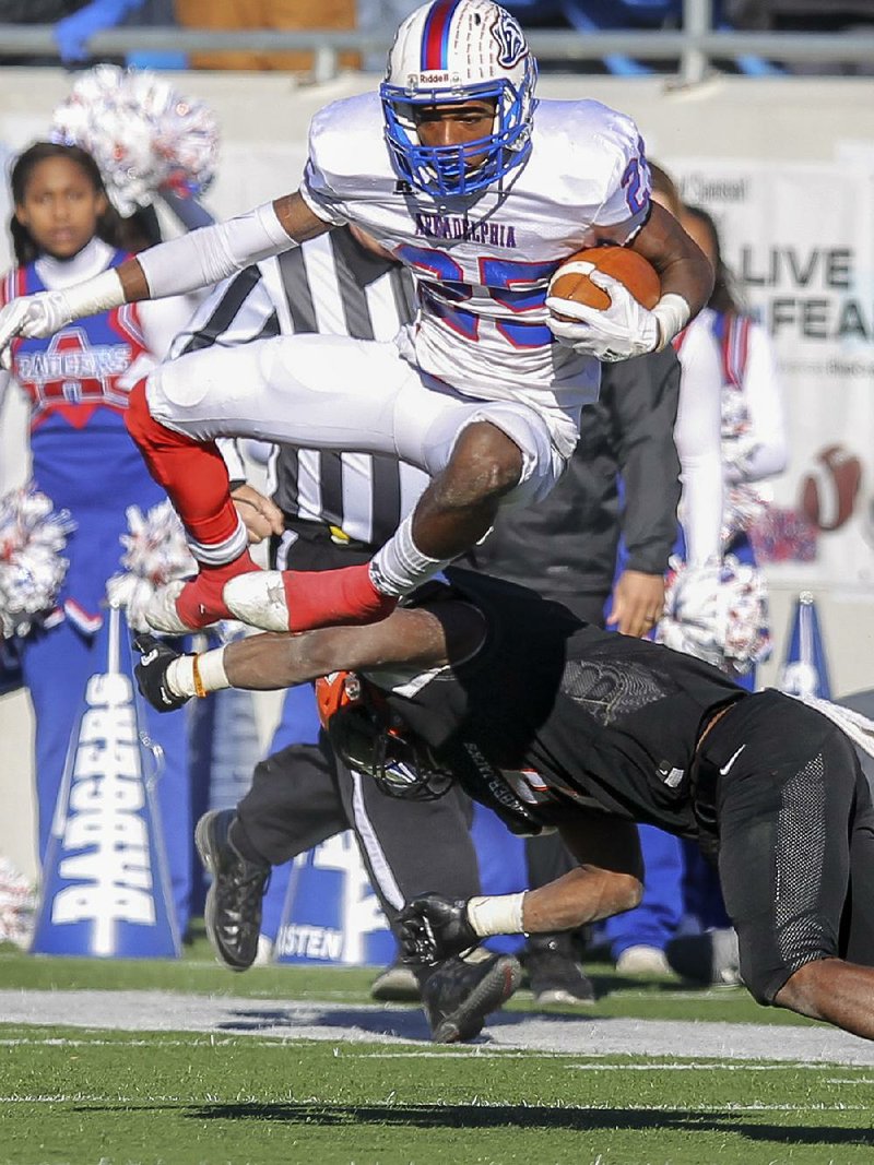 Arkadelphia’s Dillon Scott, shown leaping over a Warren defender, had a game-saving tackle and interception in the final seconds.