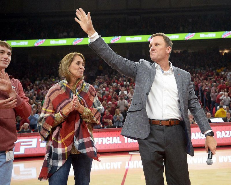 NWA Democrat-Gazette/ANDY SHUPE
Arkansas football coach Chad Morris (right) leads the crowd in a Hog call alongside his wife, Paula, during Arkansas' basketball game against Minnesota Saturday, Dec. 9, 2017, in Bud Walton Arena. Visit nwadg.com/photos to see more photographs from the game.