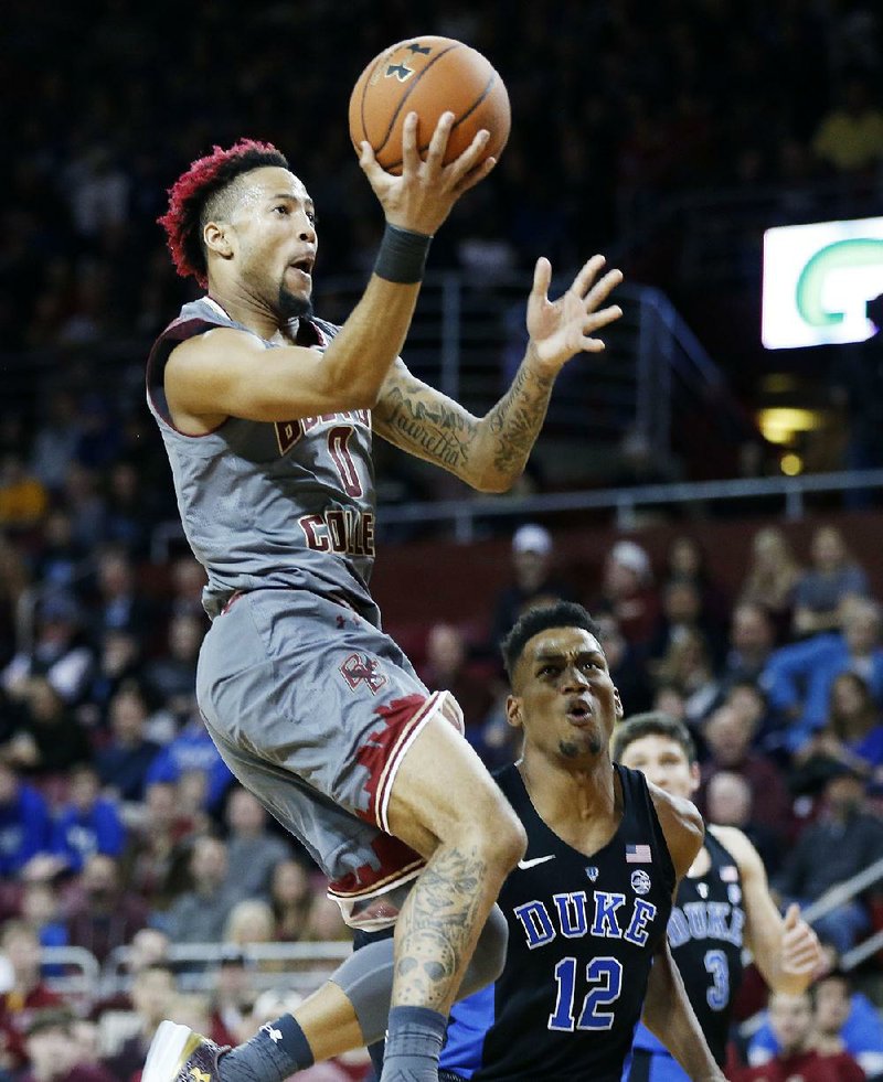 Boston College’s Ky Bowman shoots in front of Duke’s Javin DeLaurier during the fi rst half Saturday in Boston. The unranked Eagles upset the top-ranked Blue Devils 89-84.