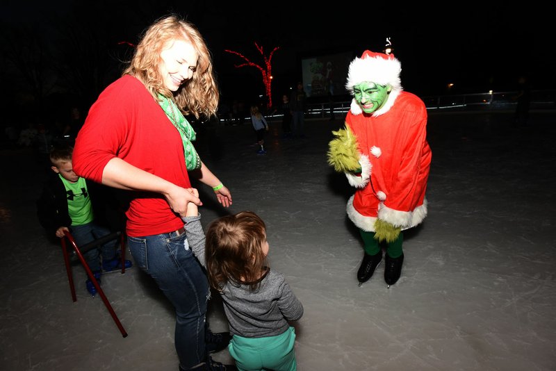 The Grinch, played by Chase Freeman of Bella Vista, greets ice skaters at The Rink at Lawrence Plaza in Bentonville during a Frosty Flix & Skate-A-Long. The next event, featuring the movie “The Santa Clause,” is Dec. 16.
