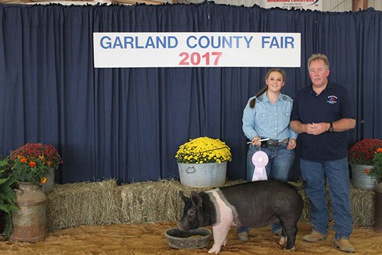 Submitted photo RESERVE GRAND CHAMPION MARKET HOG: The hog of Bailey Helton, left, won the title of Reserve Grand Champion Market Hog. Buyer was American Termite and Pest Control, represented by Bobby Adcock.