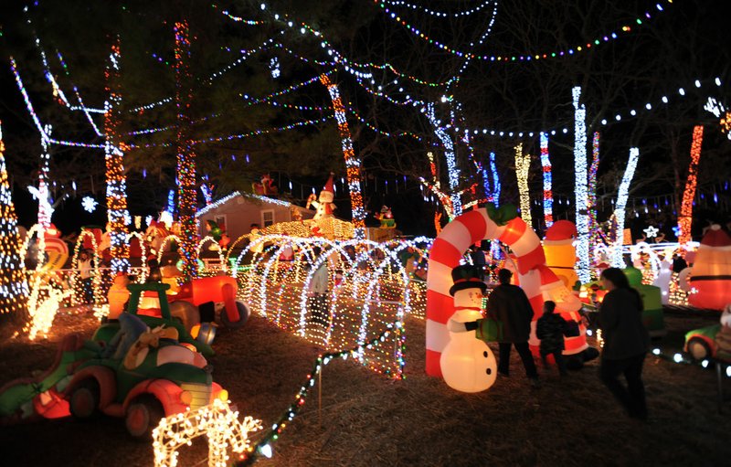 Visitors walk through inflatable statues and a display of lights at a previous Stewart family Christmas light display.