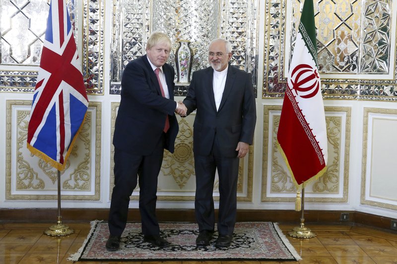 Iranian Foreign Minister Mohammad Javad Zarif, right, and his British counterpart Boris Johnson, shake hands as they pose for media prior to their talks in Tehran, Iran, Saturday, Dec. 9, 2017. Johnson arrived in Tehran Saturday, where he is expected to discuss the fate of detained British-Iranian woman Nazanin Zaghari-Ratcliffe, who is serving a five-year prison sentence for allegedly plotting to overthrow Iran's government. (AP Photo/Ebrahim Noroozi)