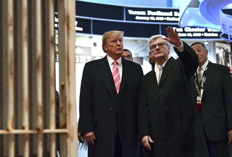 President Donald Trump, left, listens as Mississippi Gov. Phil Bryant, right, shows him the Hinds County Jail on display at the newly-opened Mississippi Civil Rights Museum in Jackson, Miss., Saturday, Dec. 9, 2017. (AP Photo/Susan Walsh)
