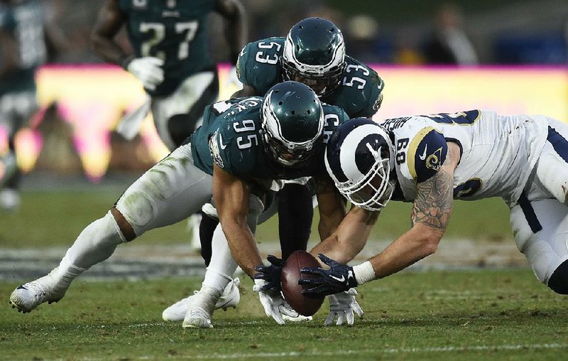 Philadelphia Eagles linebacker Mychal Kendricks (95) and Tyler Higbee of the Los Angeles Rams dive for a fumble in the fourth quarter Sunday. Philadelphia’s Rodney McLeod (not pictured) recovered the fumble, helping set up the Eagles’ go-ahead field goal.