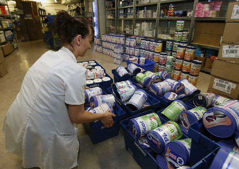 A drugstore employee removes baby milk from stock in Anglet, France, on Monday. Baby milk maker Lactalis and French authorities have ordered a recall of “several million” products after a possible salmonella contamination was identifi ed at one of the company’s plants.
