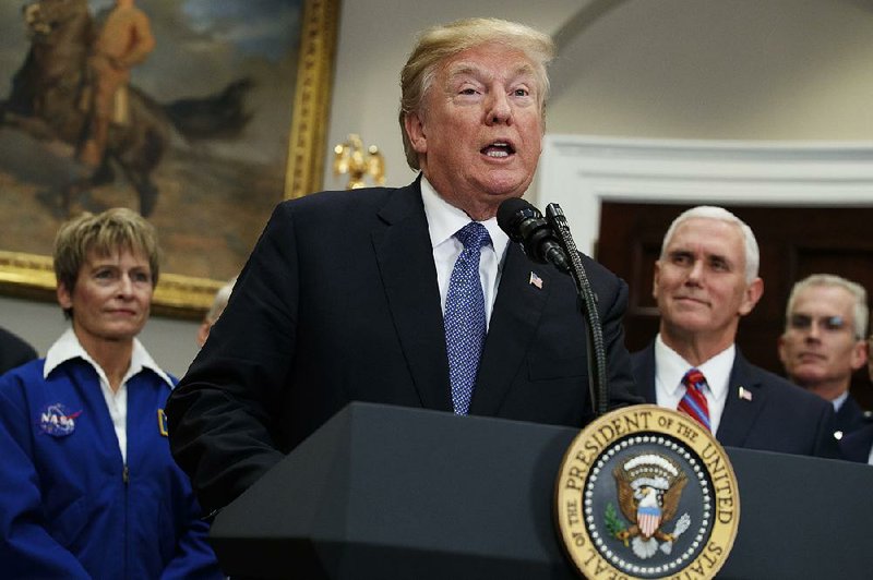 President Donald Trump speaks Monday at the White House before signing a policy directive to send American astronauts back to the moon. Behind him are (from left) NASA astronaut Peggy Whitson, Vice President Mike Pence and Vice Chairman of the Joint Chiefs of Staff Gen. Paul Selva.
