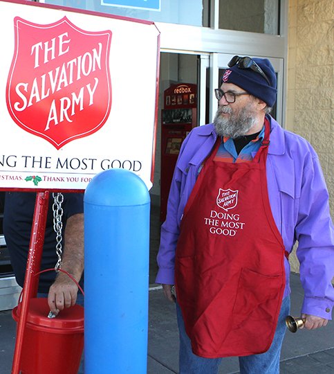 The Sentinel-Record/Richard Rasmussen JINGLE BELLS: Salvation Army volunteer Jerry Hutchinson watches as a man makes a donation while ringing a bell at a donation site for The Salvation Army's Red Kettle Drive at the Walmart on Central Avenue on Monday. The Salvation Army is still only halfway to meeting their fundraising goal for the year through Red Kettle donations.