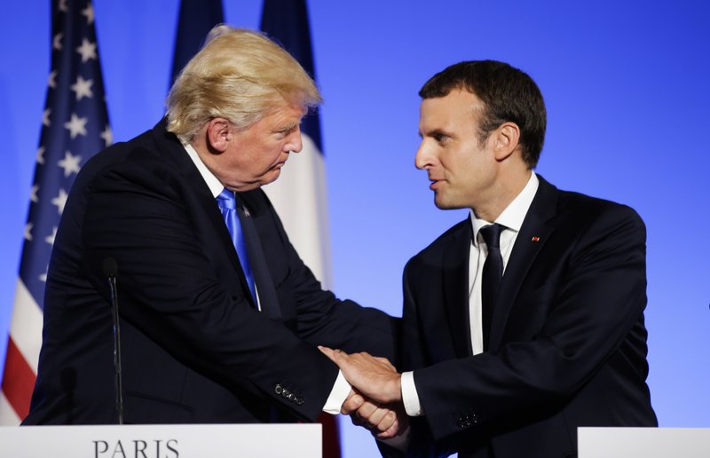 In this July 13, 2017 file photo, U.S President Donald Trump, left, shakes hands with French President Emmanuel Macron after a press conference at the Elysee Palace in Paris. Macron announced a competition for the grants hours after Trump declared he would withdraw the U.S. from the global accord reached in Paris in 2015 to reduce climate-damaging emissions. Macron is unveiling the winners Monday Dec.11, 2017 evening ahead of a climate summit. 