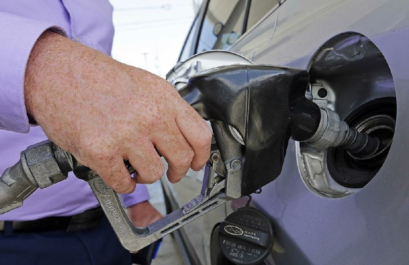 A motorist gets gas at a station in Miami in May. A 4.6 percent increase in energy costs largely fueled a rise in wholesale prices in November. 
