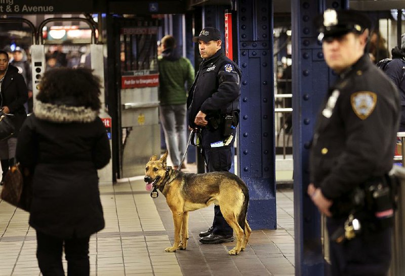 Police officers patrol a passageway connecting New York City’s Port Authority bus terminal and the Times Square subway station on Tuesday. 