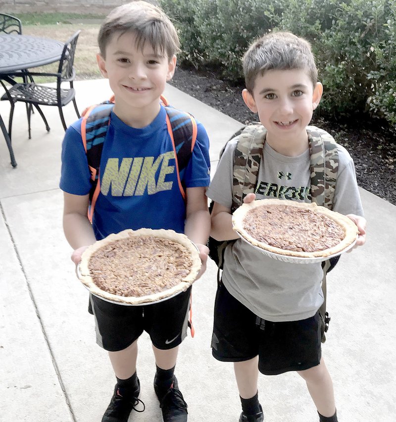 Photo submitted Logan Maddry and Kolby O'Neill show off the pecan pies they baked with PE for Life teacher Ashlee Lunsford. They were participating in a fundraiser called &quot;Gifts of Time.&quot; Lunsford volunteered her time which was auctioned off at the school carnival.