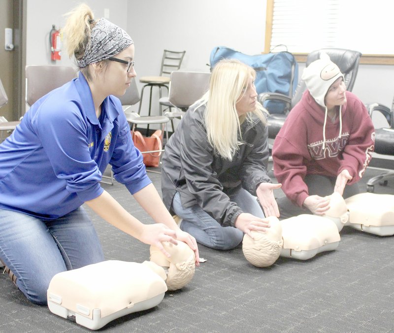 Keith Bryant/The Weekly Vista Dispatchers Diamond Neill (left), Shaylan D'andrea and Evelyn Vanness practice opening a patient's airway for CPR.