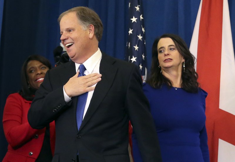Doug Jones takes the stage Tuesday night with his wife, Louise, in Birmingham after winning the Alabama special Senate election. “We have shown the country the way that we can be,” Jones said. 