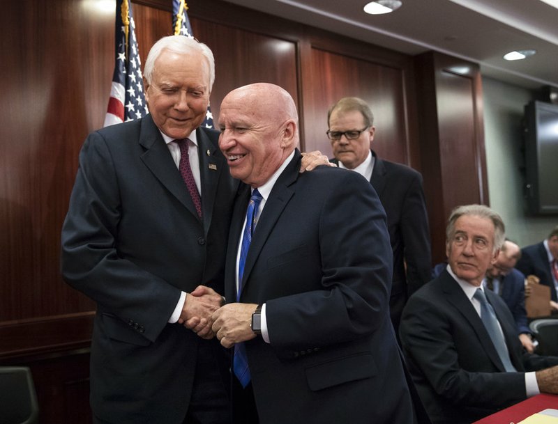 House Ways and Means Committee Chairman Kevin Brady, R-Texas, center, embraces Senate Finance Committee Chairman Orrin Hatch, R-Utah, left, as House and Senate conferees after GOP leaders announced they have forged an agreement on a sweeping overhaul of the nation's tax laws on Capitol Hill in Washington on Wednesday, Dec. 13, 2017.