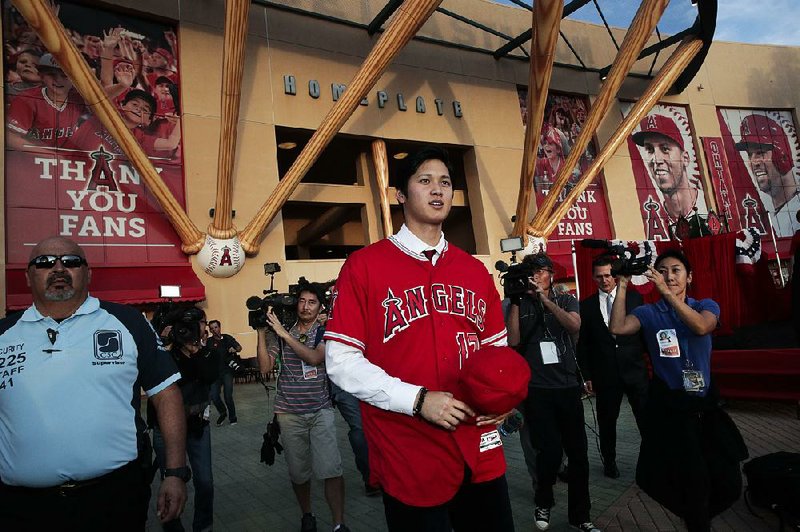 Shohei Ohtani stands outside Angel Stadium in Anaheim, Calif., on Saturday after agreeing to join the Los Angeles Angels on a minor league contract with a signing bonus of $2,315,000. Angels Manager Mike Scioscia said Wednesday that the team knew Ohtani was recovering from a mildly sprained right elbow when the two sides agreed to the deal.