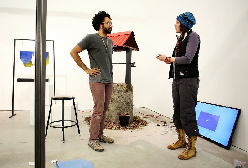 Cory Perry, a senior at the University of Arkansas, Fayetteville, talks with associate professor Bethany Springer about his final critique at the UA gallery.A $40 million grant from the Windgate Charitable Foundation will allow development of the Windgate Art and Design District a few blocks south of the campus. 