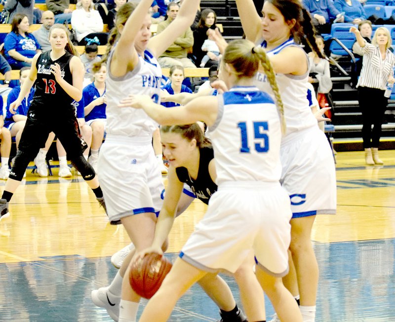 RICK PECK/SPECIAL TO MCDONALD COUNTY PRESS McDonald County's Sam Frazier looks to dribble out of trouble while being surrounded by three players from St. Mary's Colgan during the Lady Mustangs' 37-26 loss on Dec. 8 in Pittsburg, Kan.