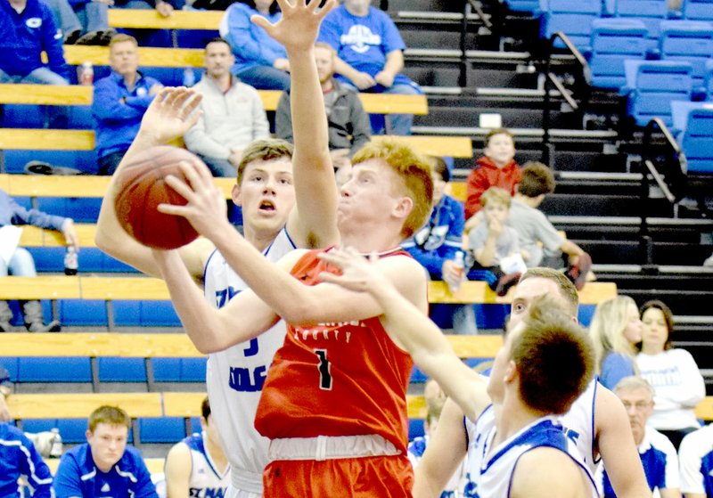 RICK PECK/SPECIAL TO MCDONALD COUNTY PRESS McDonald County's Blake Gravette drives the lane past a pair of St. Mary Colgan defenders for two of his 12 points in the Mustangs' 45-35 loss on Dec. 8 in Pittsburg, Kan.