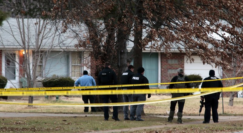 Police officers work the scene where two St. Louis County officers were shot and a man barricaded himself inside a home on Thursday, Dec. 14, 2017, in the St. Louis County town of Bellefontaine Neighbors, Mo. Officers are trying to negotiate his surrender.