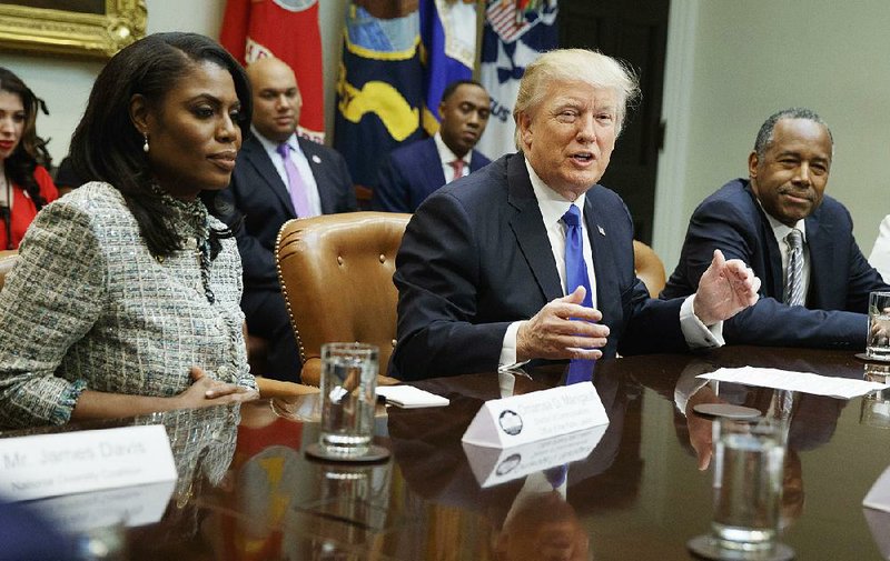 In this Feb. 1, 2017, file photo, President Donald Trump speaks during a meeting on African American History Month in the Roosevelt Room of the White House in Washington. From left are, Omarosa Manigault, Trump, and then-Housing and Urban Development Secretary-designate Ben Carson. 