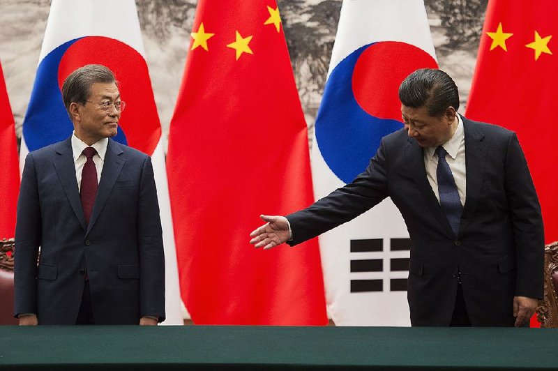 South Korean President Moon Jae-in (left) joins Chinese President Xi Jinping for a signing ceremony Thursday inside the Great Hall of the People in Beijing.