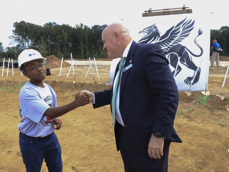 Little Rock School District Superintendent Michael Poore talks with Mabelvale Middle School student Dylan Hewing, 12, following a groundbreaking ceremony for the new Southwest High School on Oct. 2, 2017.
