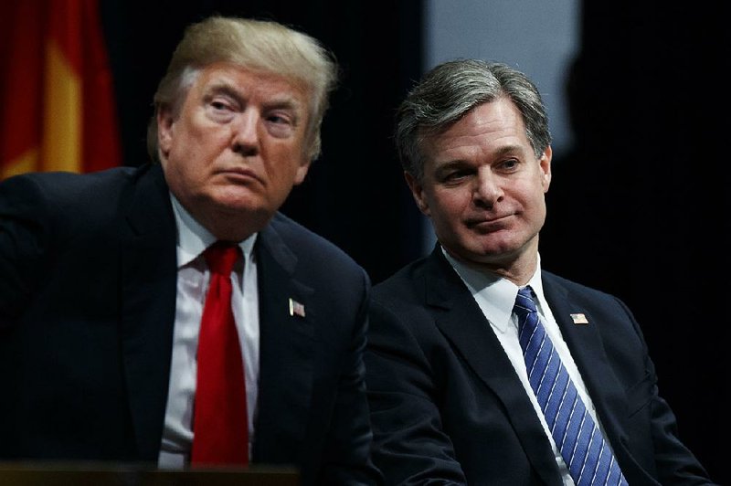 President Donald Trump sits with FBI Director Christopher Wray at graduation ceremonies Friday at the FBI Academy in Quantico, Va., after launching a scathing attack on the FBI. 