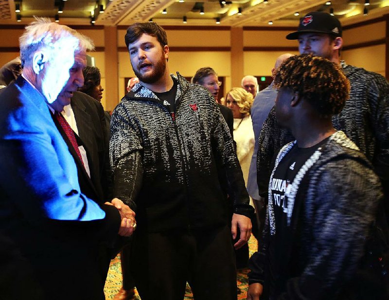 Arkansas State linebacker Ben Gallagher (center) shakes hands with former University of Alabama head coach Gene Stallings after Stallings received the Alabama Football Legend Award on Friday at the Camellia Bowl luncheon.