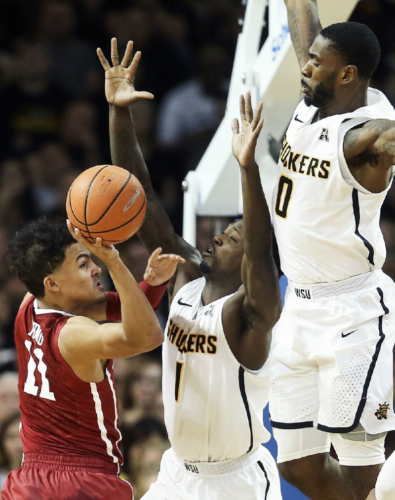 Oklahoma guard Trae Young (left) looks to throw a pass while being defended by Wichita State’s Zach Brown (center) and Rashard Kelly during the second half of the Sooners’ 91-83 victory over the No. 3 Shockers on Saturday in Wichita, Kan. Young finished with 29 points and 10 assists for the Sooners. 