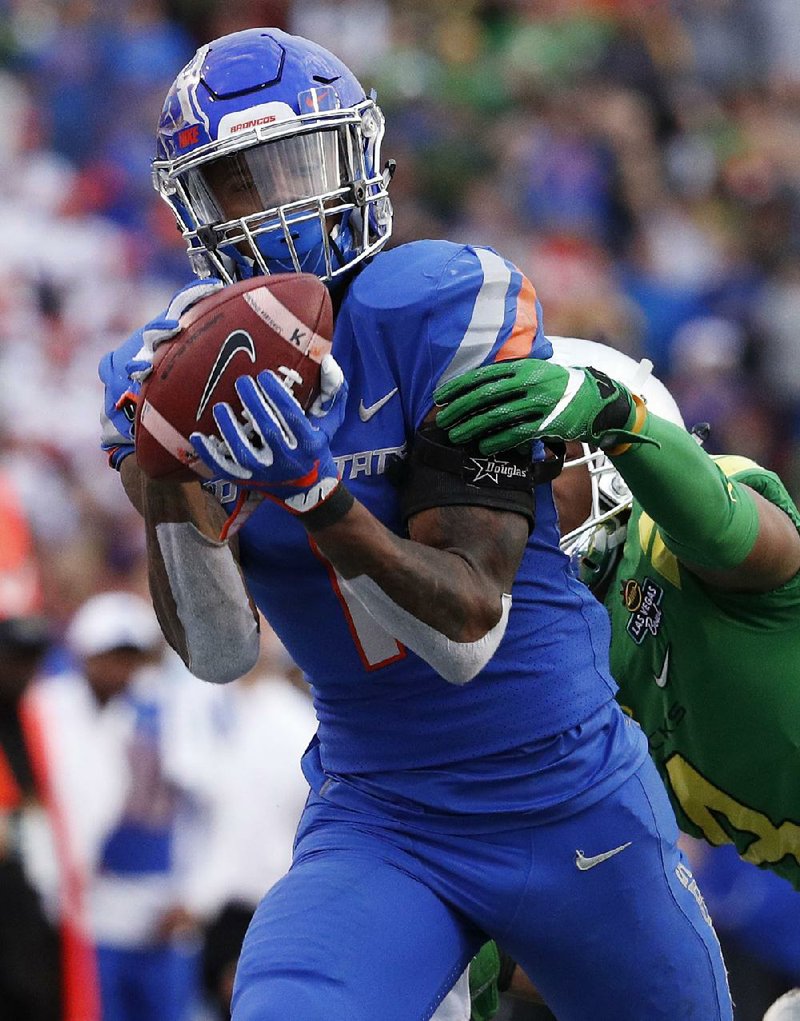 Boise State wide receiver Cedrick Wilson catches a pass over Oregon cornerback Thomas Graham Jr. during the second half of the Las Vegas Bowl on Saturday in Las Vegas. Wilson caught 10 passes for 221 yards and a touchdown to help the Broncos win 38-28.