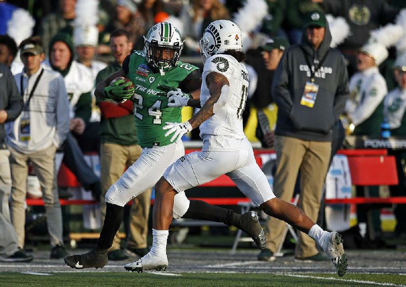Marshall running back Keion Davis (left) eludes Colorado State safety Jordan Fogal while rushing to the end zone to score a touchdown during the first half of the New Mexico Bowl on Saturday in Albuquerque, N.M. Davis rushed for 141 yards and a touchdown as Marshall won 31-28. 