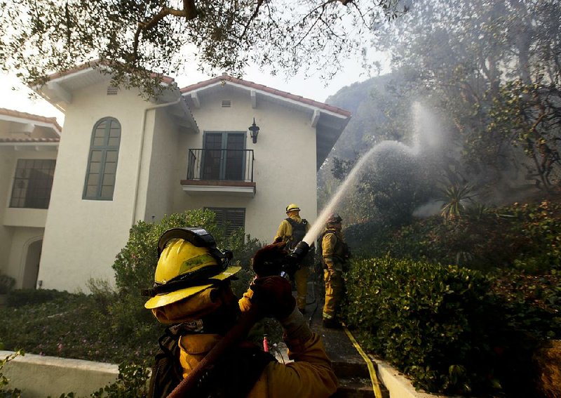 Firefighters work to put out hot spots from a wildfire Saturday in Montecito, Calif. 