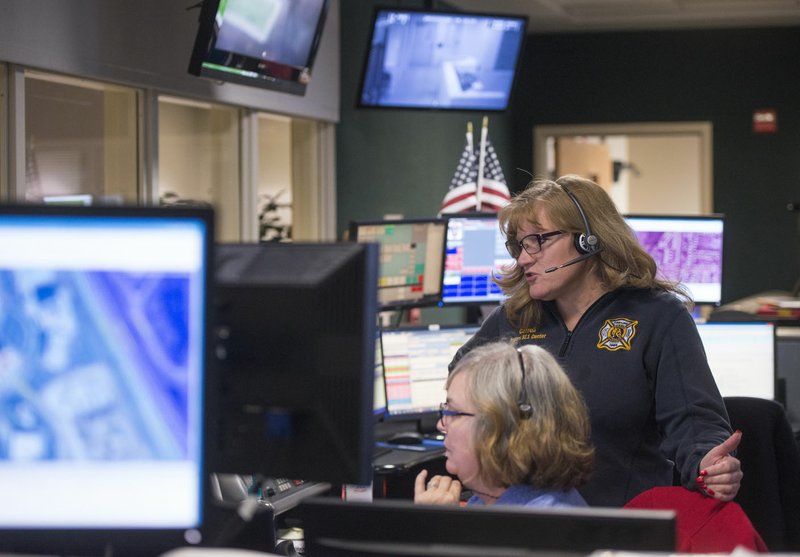 NWA Democrat-Gazette/BEN GOFF • @NWABENGOFF Michella Epps (left), telecommunicator, confers Dec. 6 with Donna Carrell, dispatch center shift supervisor, in the Rogers 911 Center at the Rogers Police Department. Psychiatric call volumes aren’t tracked statewide, but emergency officials in various counties have told state officials about increases, said James Bledsoe, EMS and trauma medical director at the Arkansas Department of Health.