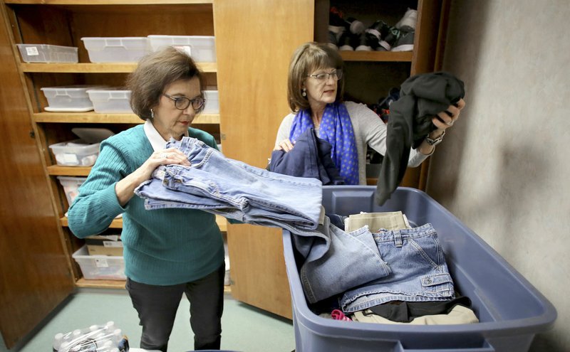 NWA Democrat-Gazette/DAVID GOTTSCHALK Kathy Launder (right), Springdale School District nursing supervisor, and Beverly Charleton, social services, unpack and store clothing items Thursday in the new clothing closet and food pantry at the Central Support Services Nursing Department in Springdale. The department is moving into the new facility on south Thompson Street.