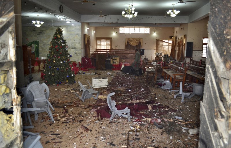 A Pakistani walks in the main hall of a church following a suicide attack in Quetta, Pakistan, Sunday, Dec. 17, 2017. Two suicide bombers attacked the church when hundreds of worshippers were attending services at the church ahead of Christmas. 