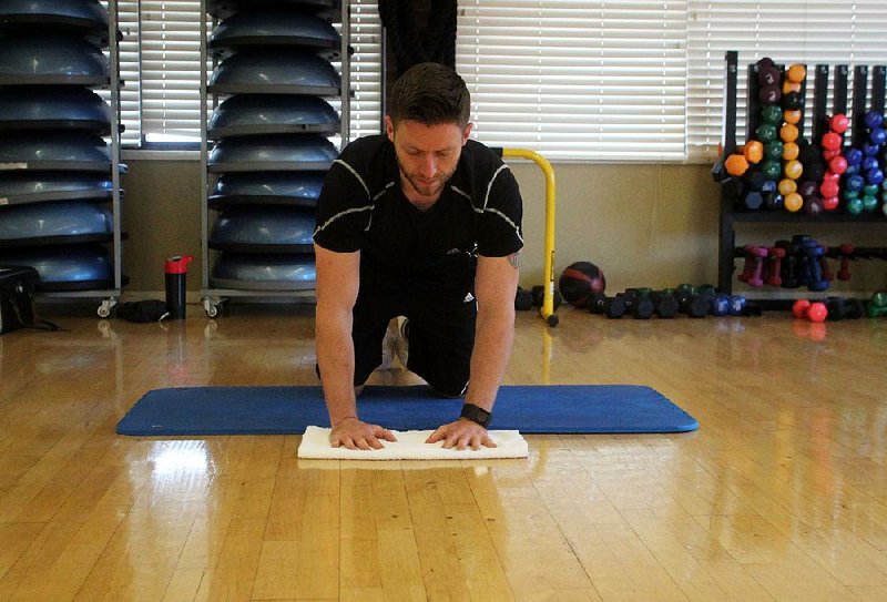Josh Holt does steps 1, 3 and 5 of the V Slide exercise using a towel 