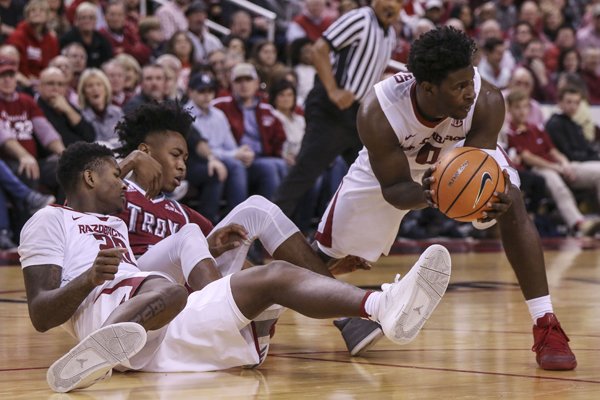 Arkansas guard Jaylen Barford (right) comes away with a turnover during a game against Troy on Saturday, Dec. 16, 2017, in North Little Rock.