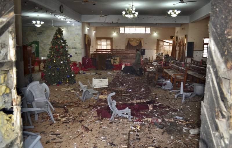 A Pakistani walks in the main hall of a church following a suicide attack in Quetta, Pakistan, Sunday, Dec. 17, 2017. Two suicide bombers attacked the church when hundreds of worshippers were attending services at the church ahead of Christmas. (AP Photo/Arshad Butt)