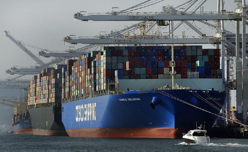 Container ships are unloaded at the Port of Oakland in California last week. The Commerce Department reported Tuesday that the U.S.’ current account trade deficit dropped to its lowest level since the third quarter of 2014. 