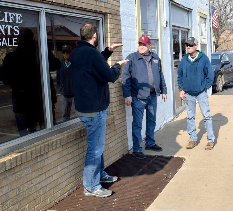 Westside Eagle Observer/MIKE ECKELS Rick McGraw (left), with McClelland Engineering, explains the changes to the sidewalk system in downtown Decatur to James Boston, director of public works, and Troy Wackes Dec. 14. Decatur will soon get a new crosswalk near the old taxidermy shop on Main Street.